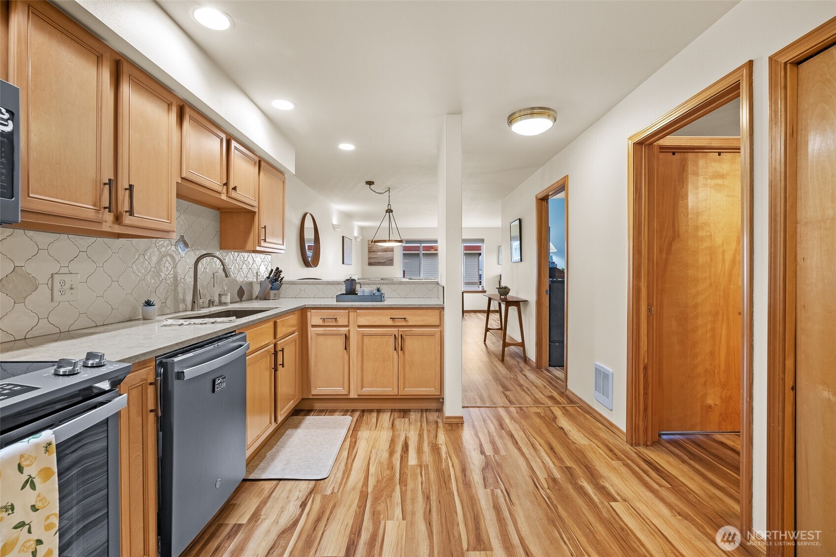 1011 Bancroft Street, Unit 204 Bellingham, WA 98225 - Photo 2 of 32 a kitchen with stainless steel appliances granite countertop a refrigerator a sink dishwasher a stove and white countertops with wooden floor