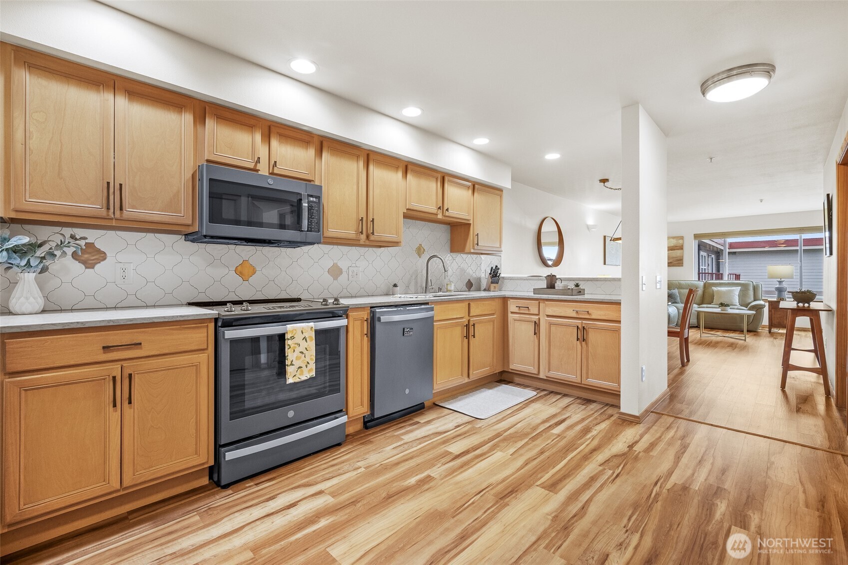 1011 Bancroft Street, Unit 204 Bellingham, WA 98225 - Photo 4 of 32 a kitchen with stainless steel appliances granite countertop a stove top oven a sink dishwasher and white cabinets with wooden floor