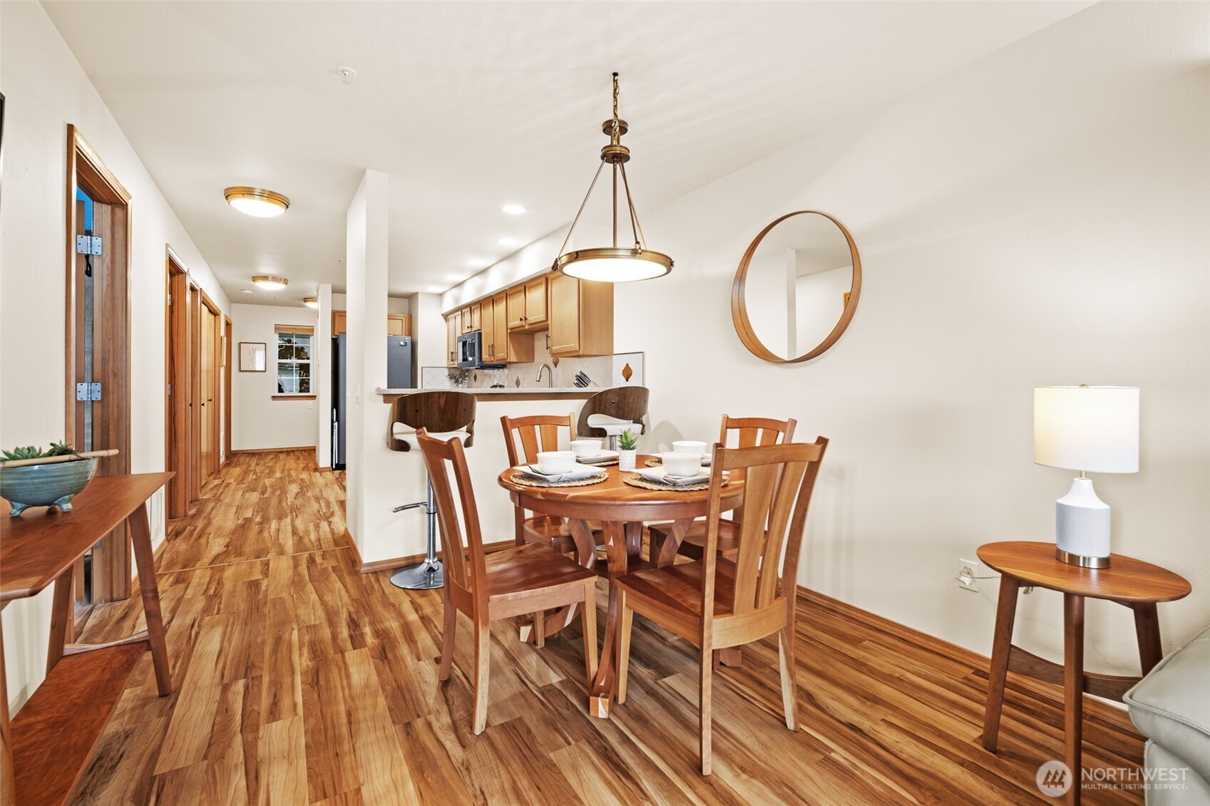 1011 Bancroft Street, Unit 204 Bellingham, WA 98225 - Photo 7 of 32 a dining room with wooden floor a chandelier a wooden table and chairs