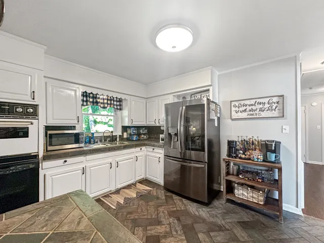 a kitchen with granite countertop a sink stove and cabinets