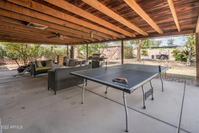 a view of a swimming pool with a table and chairs in front of it