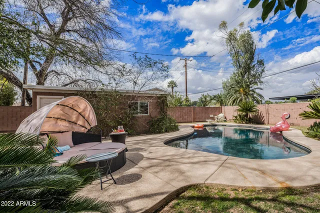 a swimming pool with outdoor seating and yard