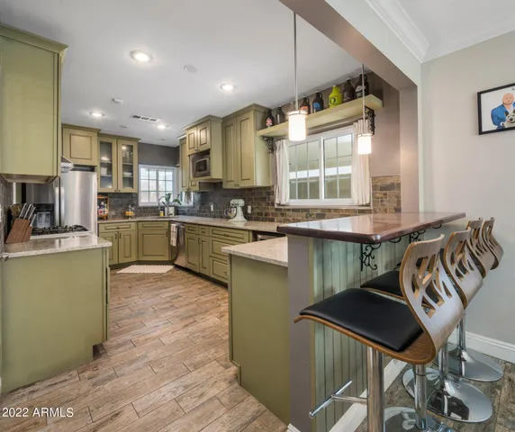 a kitchen with stainless steel appliances kitchen island granite countertop a sink and cabinets