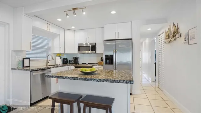a kitchen with a sink refrigerator and cabinets