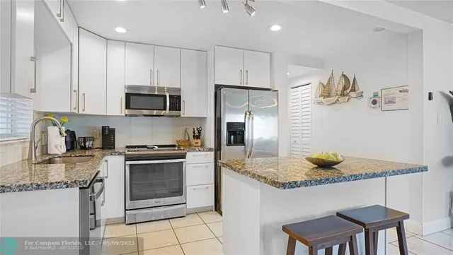 a kitchen with stainless steel appliances granite countertop a stove a refrigerator and a microwave