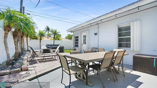 a view of a patio with table and chairs and a barbeque