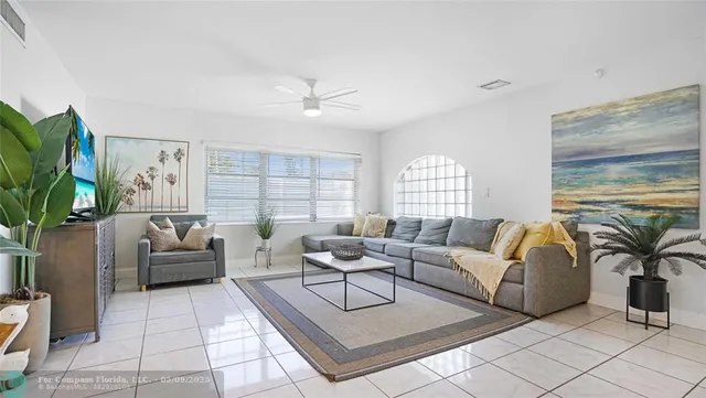 a kitchen with granite countertop stainless steel appliances a sink a stove a refrigerator cabinets and living room view