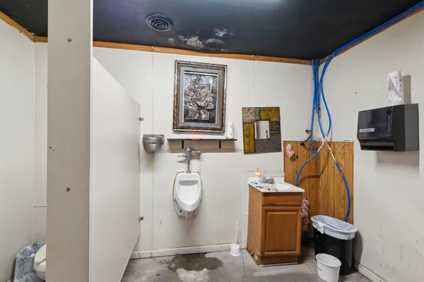 a bathroom with a toilet sink washing machine and mirror