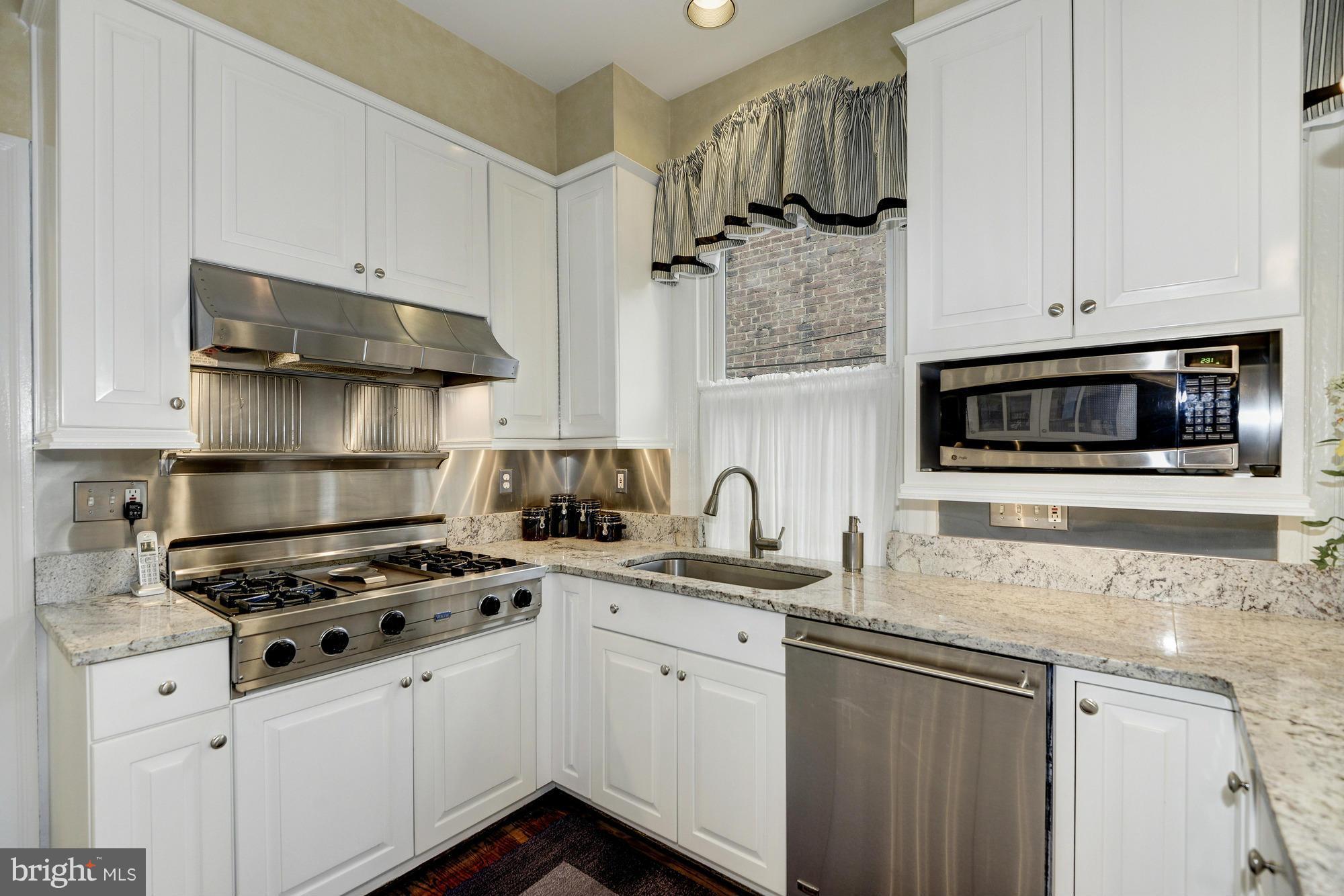 1616 S Street Northwest Washington, DC 20009 - Photo 14 of 30 a kitchen with stainless steel appliances a sink stove and cabinets
