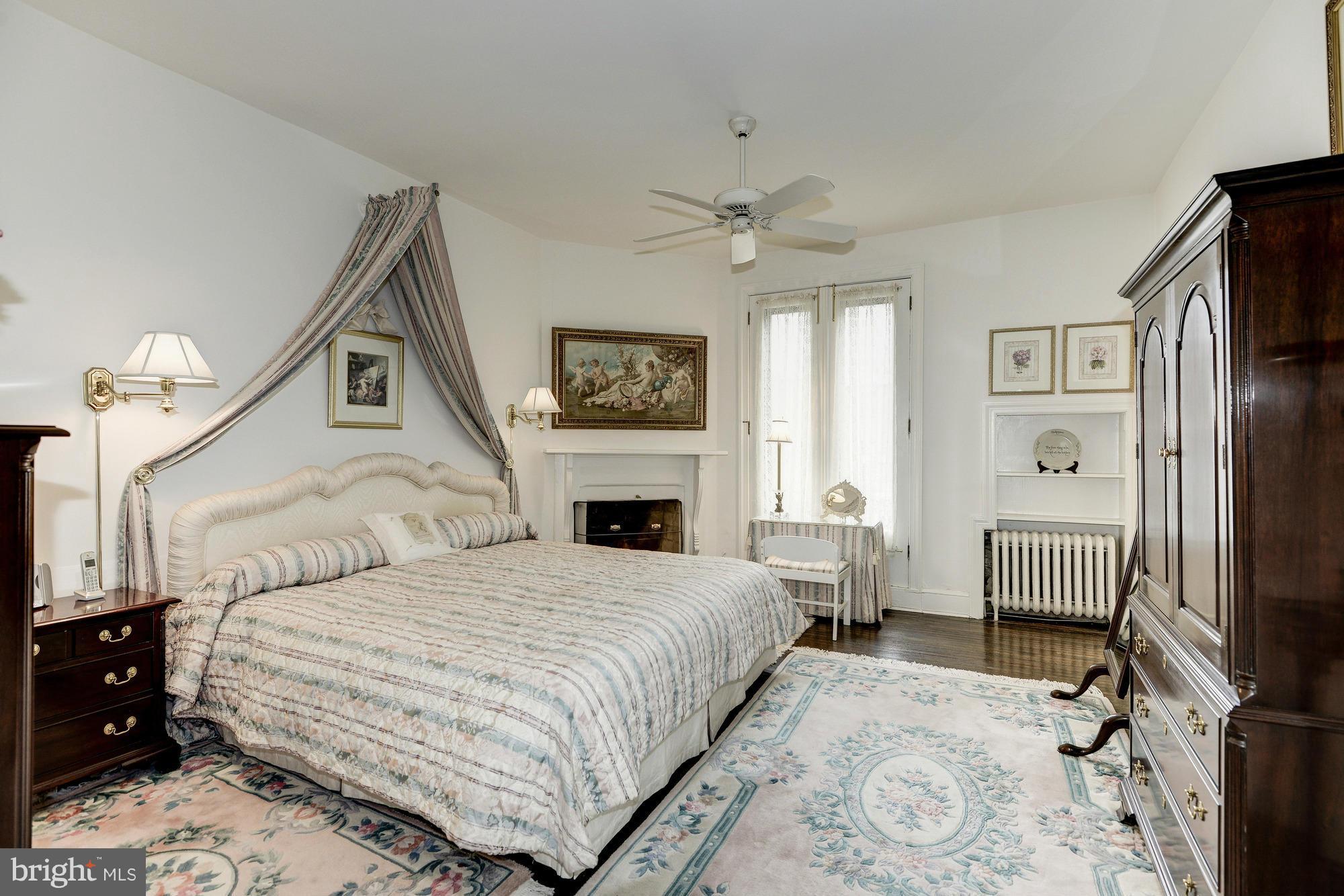 1616 S Street Northwest Washington, DC 20009 - Photo 18 of 30 a bedroom with a bed a fireplace and a flat tv screen