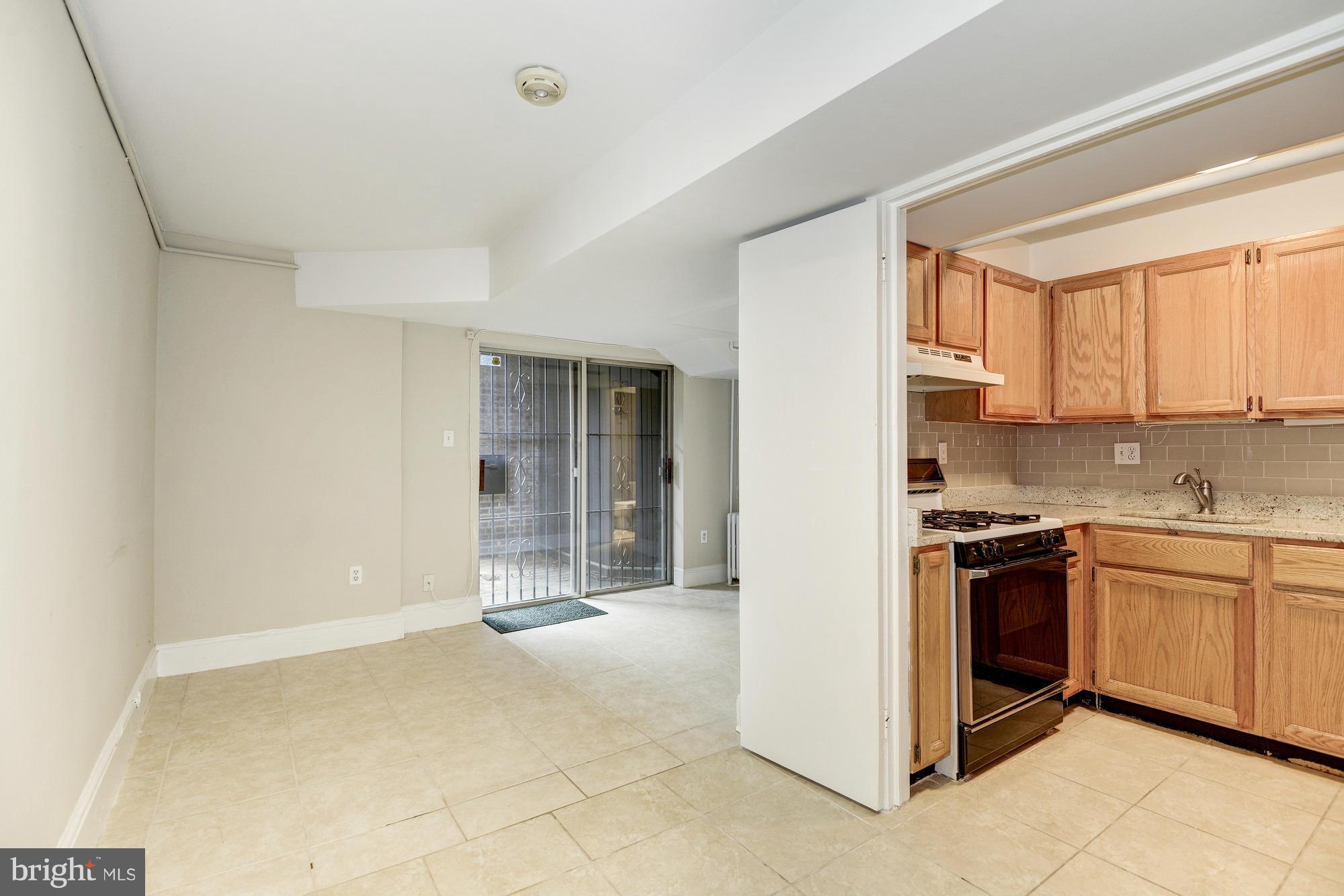 1616 S Street Northwest Washington, DC 20009 - Photo 27 of 30 a kitchen with stainless steel appliances granite countertop a stove and a refrigerator
