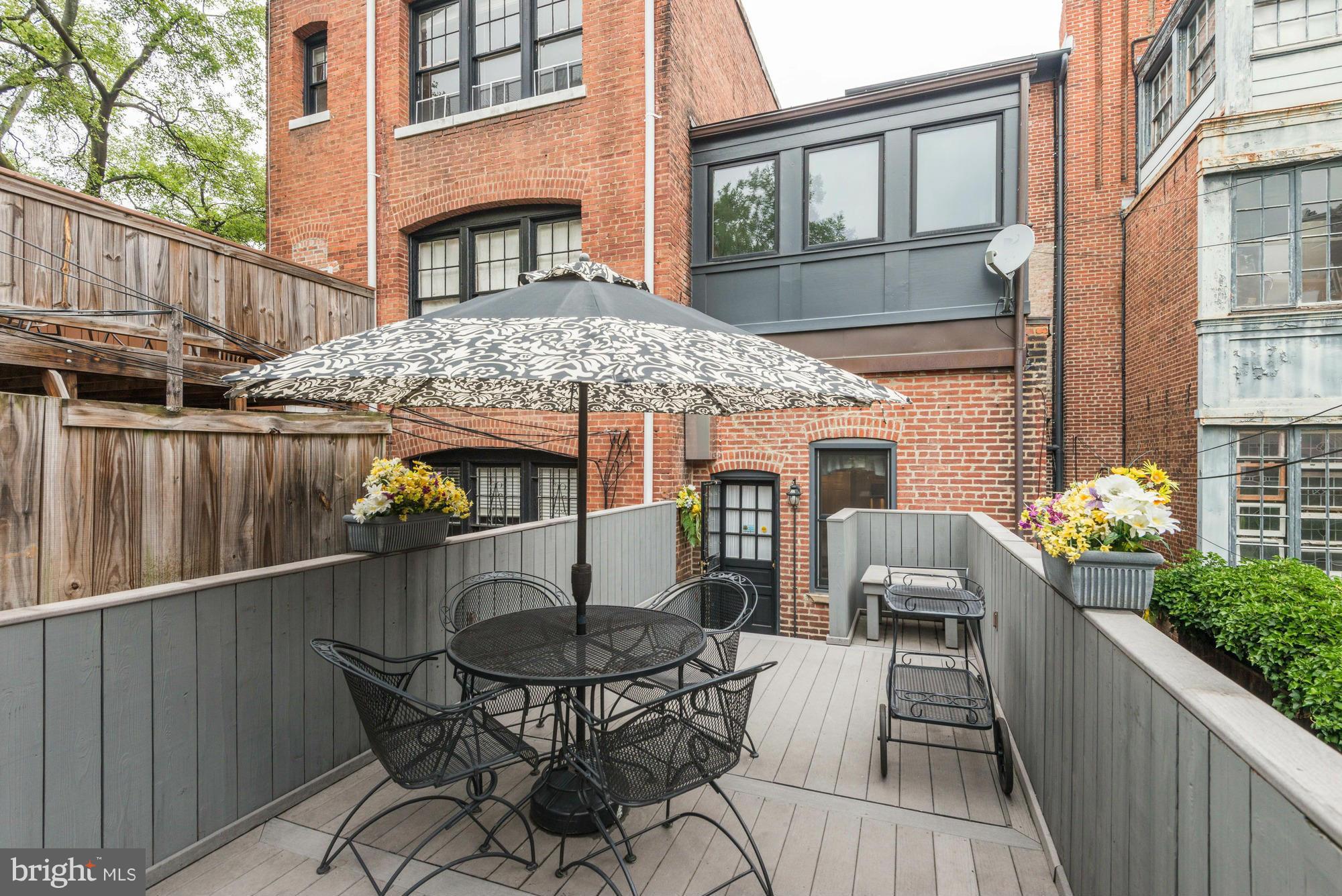 1616 S Street Northwest Washington, DC 20009 - Photo 29 of 30 a backyard of a house with table and chairs