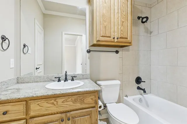 a bathroom with a granite countertop sink a toilet and a mirror