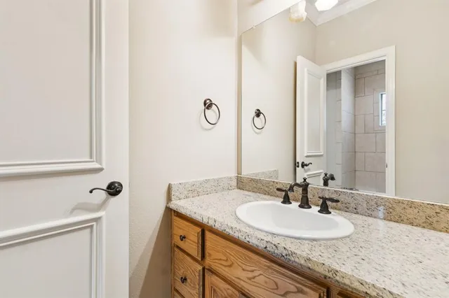 a bathroom with a granite countertop sink and a mirror