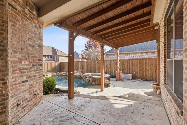 a view of a patio with table and chairs and a barbeque