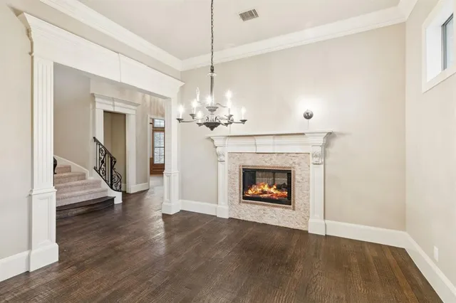 a view of an empty room with wooden floor fireplace and a window