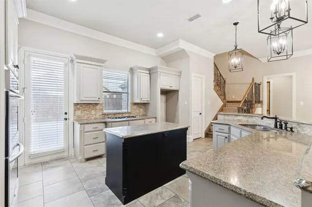 a kitchen with stainless steel appliances granite countertop a sink a stove and a refrigerator