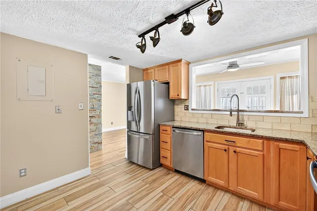 a kitchen with stainless steel appliances granite countertop a refrigerator and a sink