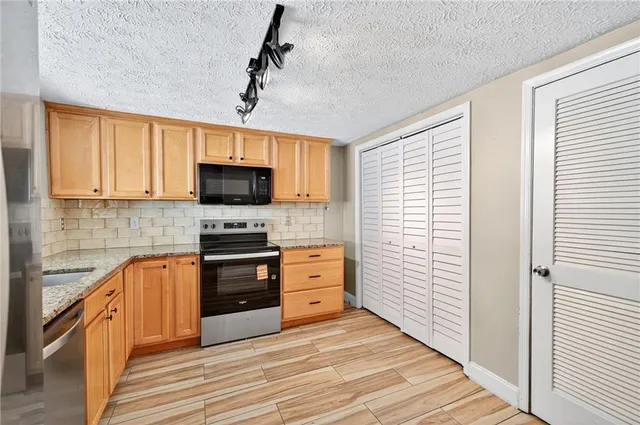 a kitchen with stainless steel appliances a stove sink and microwave