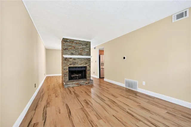 a view of a livingroom with wooden floor and a fireplace