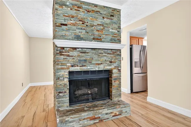a living room with a fireplace and wooden floor