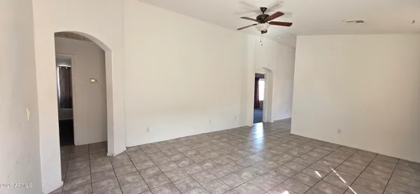 a view of an empty room with a ceiling fan