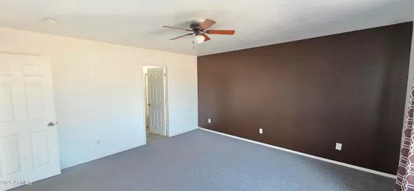 an empty room and a ceiling fan in closet with a ceiling fan