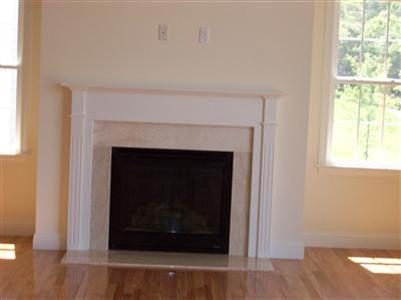 74 Brookside Road, Unit 202 Bourne, MA 02532 - Photo 6 of 6 a living room with a fireplace and a wooden floor