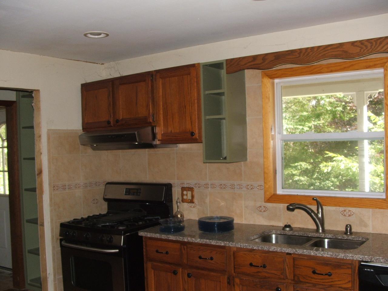 13 Curtin Road Peru, MA 01235 - Photo 4 of 11 a kitchen with stainless steel appliances wooden cabinets and a stove top oven