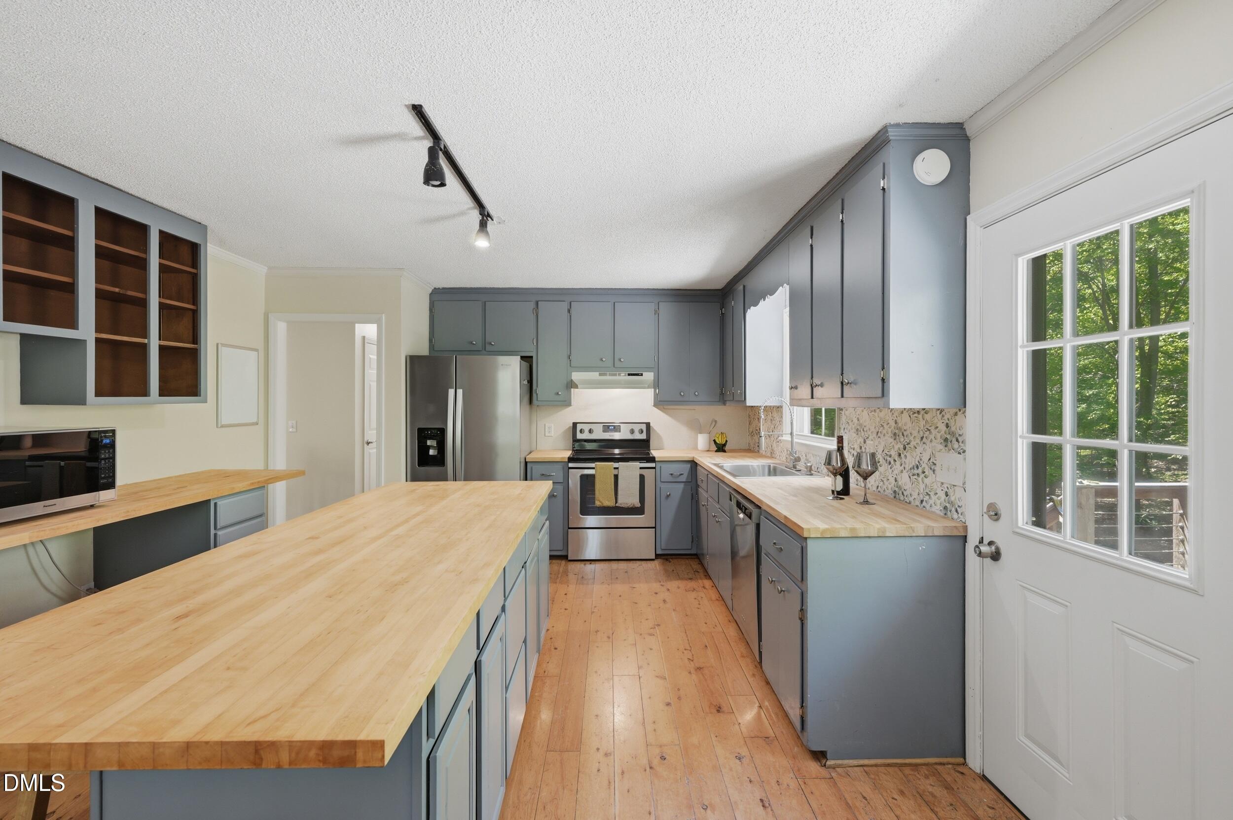 7811 Buckhorn Road Hillsborough, NC 27278 - Photo 11 of 47 a large kitchen with kitchen island a large counter top space a sink stainless steel appliances and cabinets