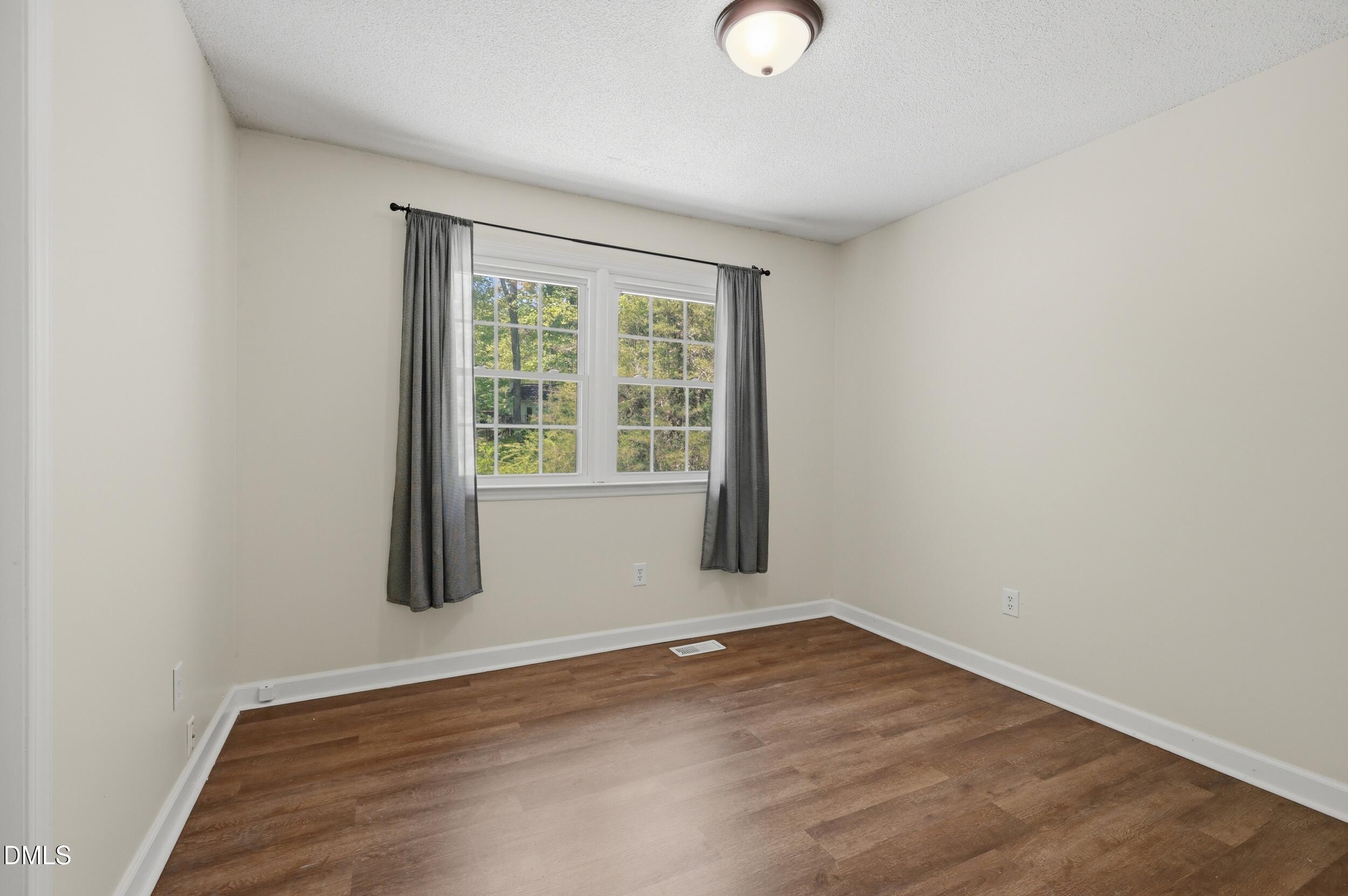 7811 Buckhorn Road Hillsborough, NC 27278 - Photo 17 of 47 an empty room with wooden floor and windows