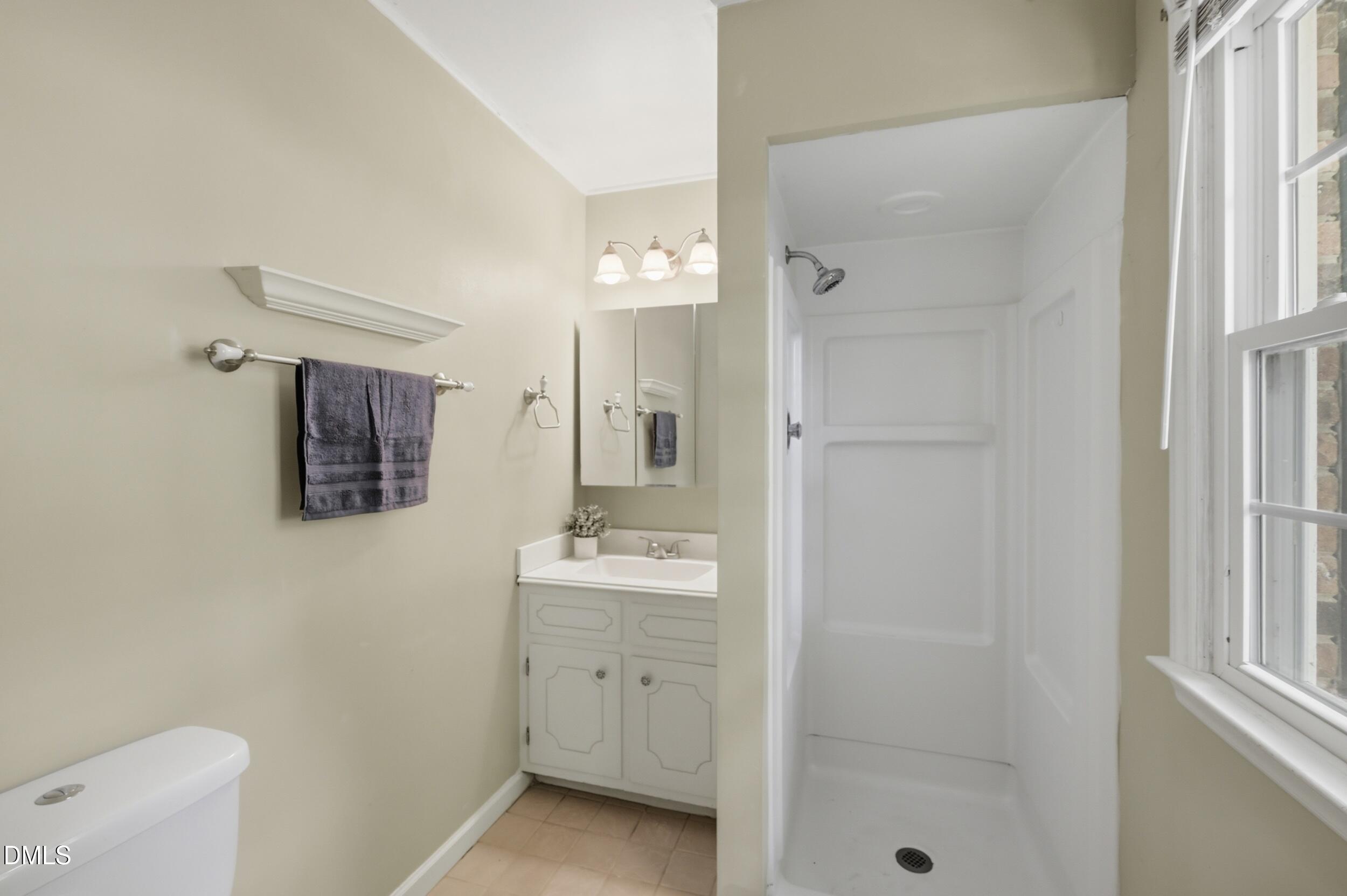 7811 Buckhorn Road Hillsborough, NC 27278 - Photo 23 of 47 a bathroom with a granite countertop sink a mirror a shower and vanity