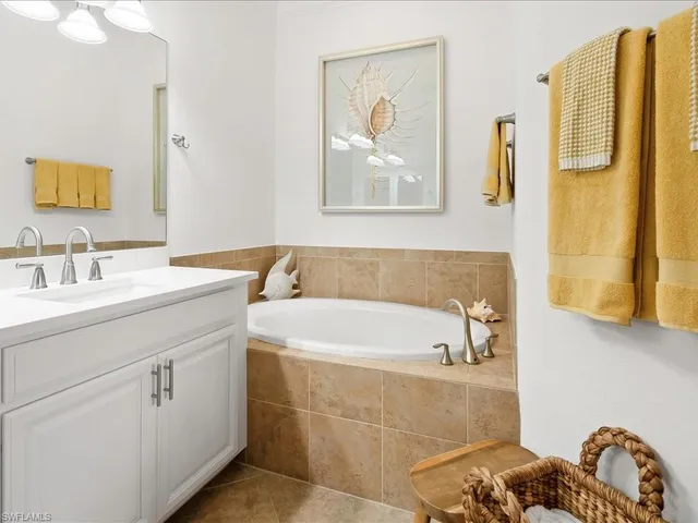 a bathroom with a tub sink and mirror