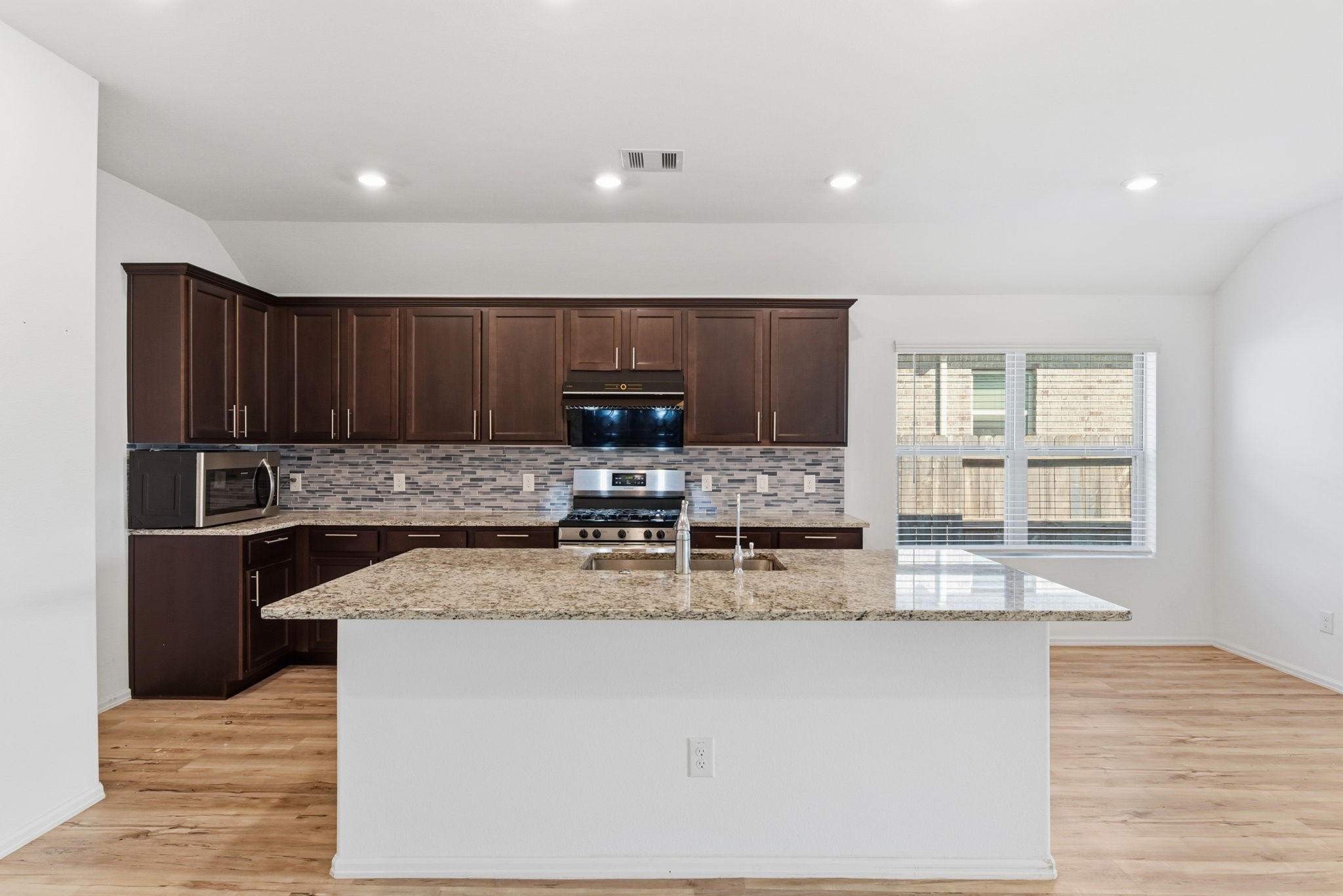 9010 Brazos Drive Baytown, TX 77521 - Photo 11 of 37 a kitchen with stainless steel appliances granite countertop a stove a sink and a microwave