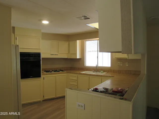 a kitchen with stainless steel appliances granite countertop a sink stove and cabinets