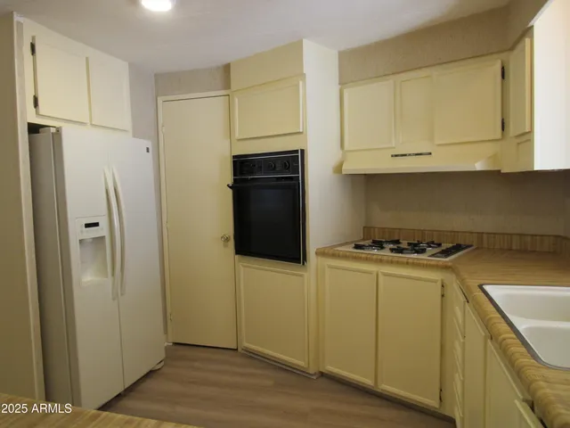 a kitchen with stainless steel appliances a refrigerator and a stove top oven