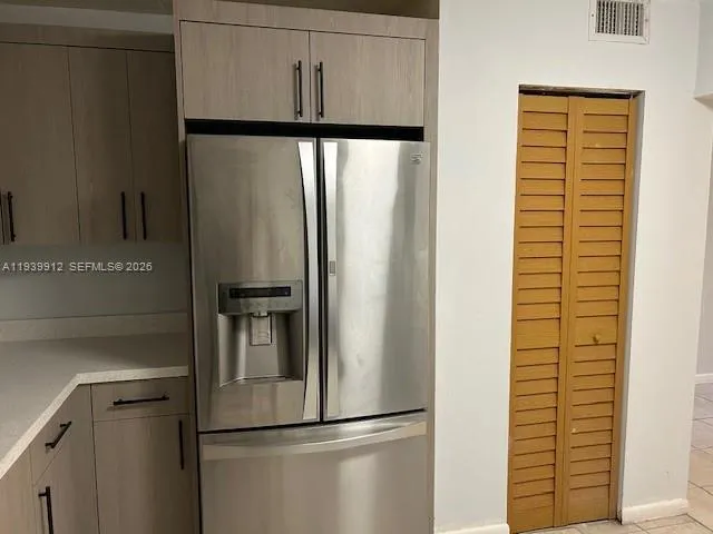 a metallic refrigerator freezer sitting in a kitchen
