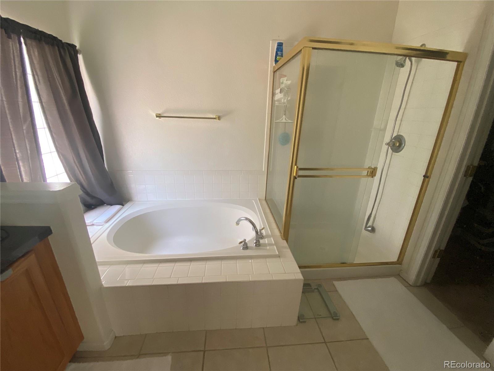 7100 Cerney Circle Castle Pines, CO 80108 - Photo 12 of 22 a bathroom with a tub and a shower
