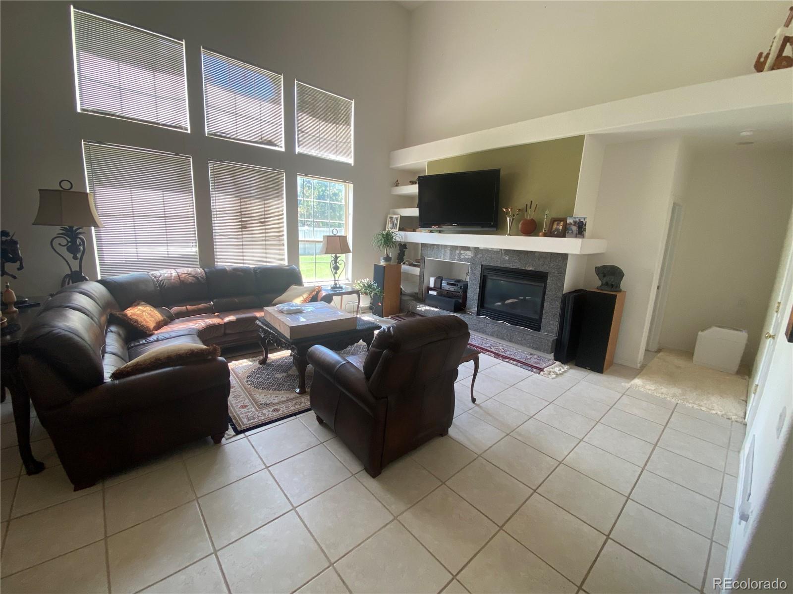7100 Cerney Circle Castle Pines, CO 80108 - Photo 5 of 22 a living room with furniture a flat screen tv and a fireplace