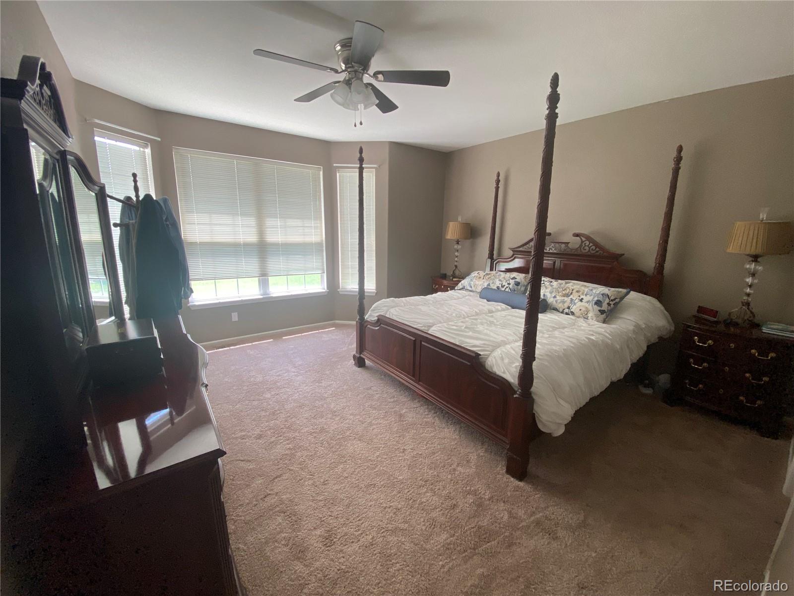 7100 Cerney Circle Castle Pines, CO 80108 - Photo 9 of 22 a spacious bedroom with a bed and large windows