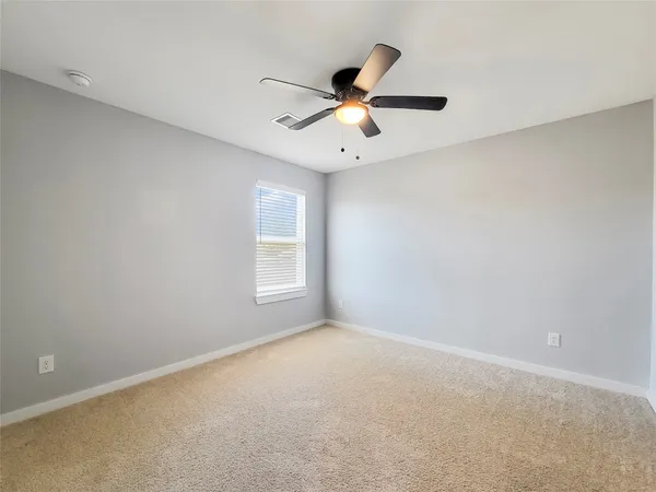 an empty room with a window and a fan