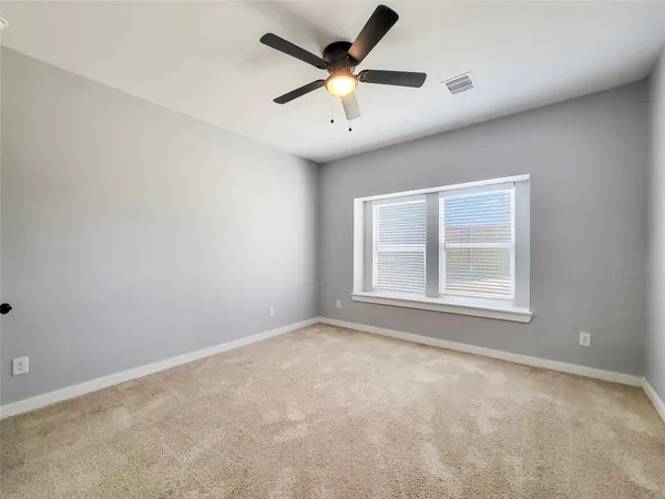 an empty room with closet and fan