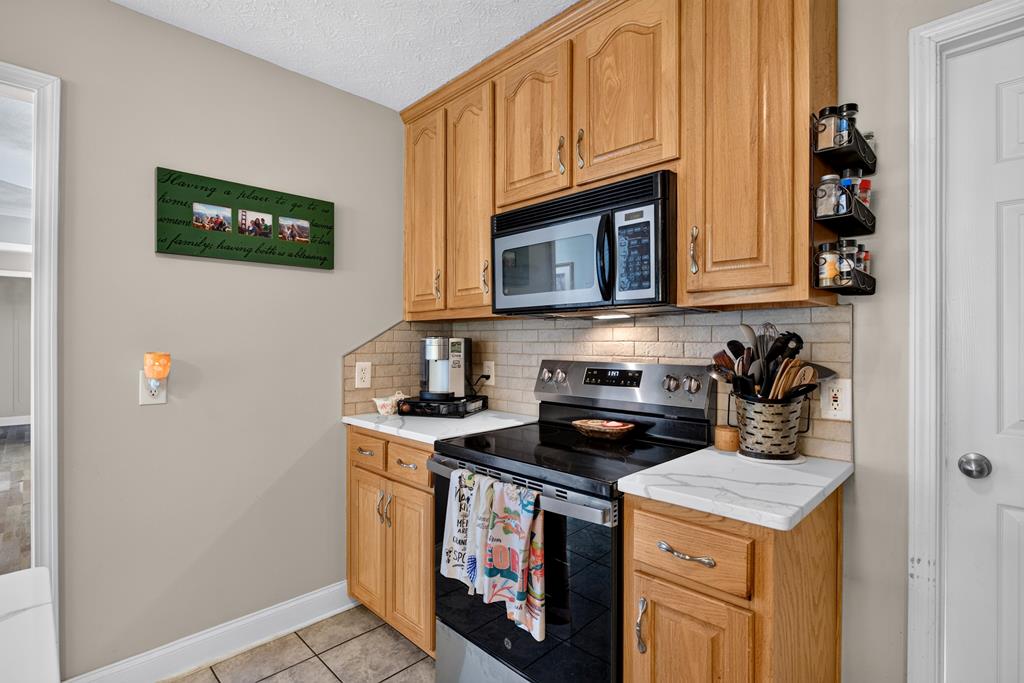 481 Sand Pit Road Mauk, GA 31058 - Photo 17 of 50 a kitchen with stainless steel appliances granite countertop a stove a sink and a microwave
