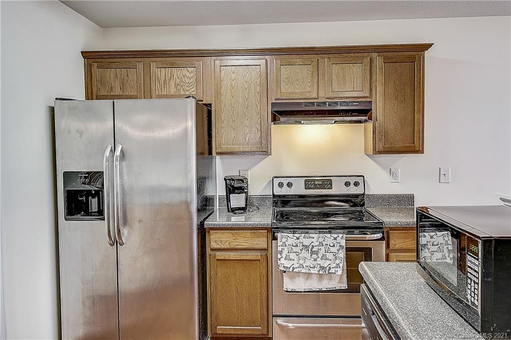 7029 Sunman Road Charlotte, NC 28216 - Photo 14 of 33 a kitchen with refrigerator a stove a sink and cabinets