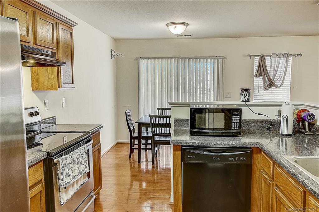 7029 Sunman Road Charlotte, NC 28216 - Photo 15 of 33 a kitchen with stainless steel appliances granite countertop a stove a sink and a microwave