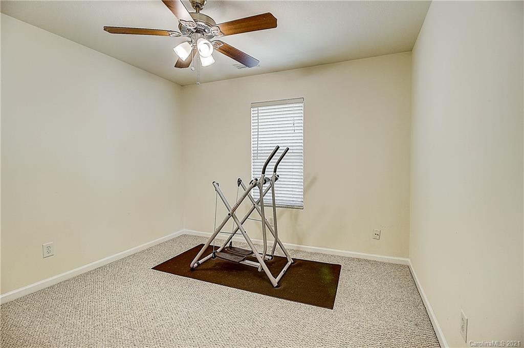 7029 Sunman Road Charlotte, NC 28216 - Photo 26 of 33 a room with gym equipment and a ceiling fan