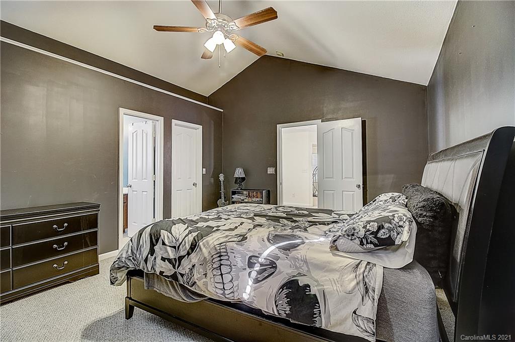 7029 Sunman Road Charlotte, NC 28216 - Photo 30 of 33 a bedroom with a bed and a chandelier
