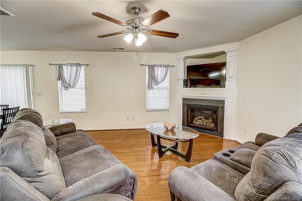 7029 Sunman Road Charlotte, NC 28216 - Photo 6 of 33 a living room with furniture a flat screen tv and a fireplace