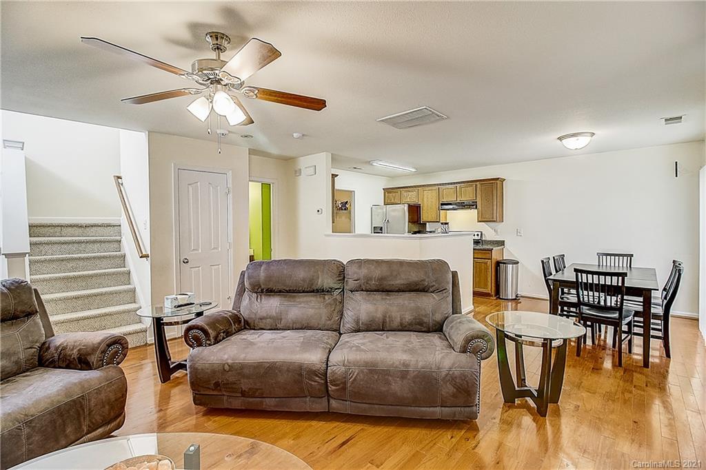 7029 Sunman Road Charlotte, NC 28216 - Photo 8 of 33 a living room with furniture and a dining table with wooden floor