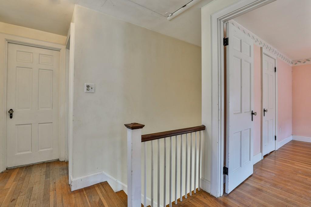 554 Brook Road Milton, MA 02186 - Photo 13 of 22 a view of a hallway with wooden floor and staircase